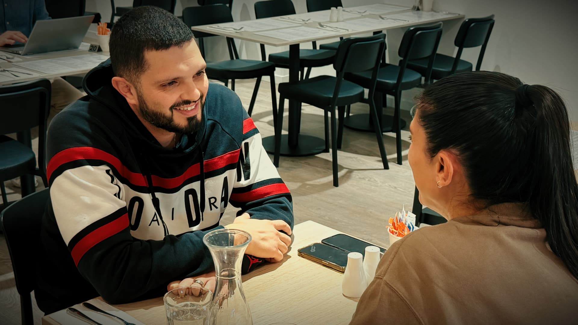 Two customers chatting and smiling at a table in the bright dining area of No9 The Cafe.