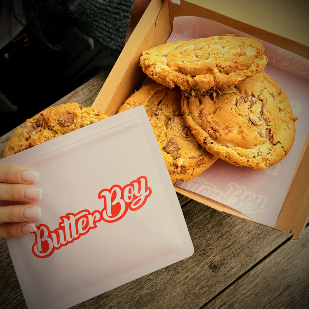 Box of ButterBoy gourmet cookies with a branded bag on a timber table at No9 The Cafe.
