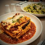 Golden baked beef lasagna with spinach and Parmesan on Bolognaise sauce, penne pesto behind, at No9, Caroline Springs